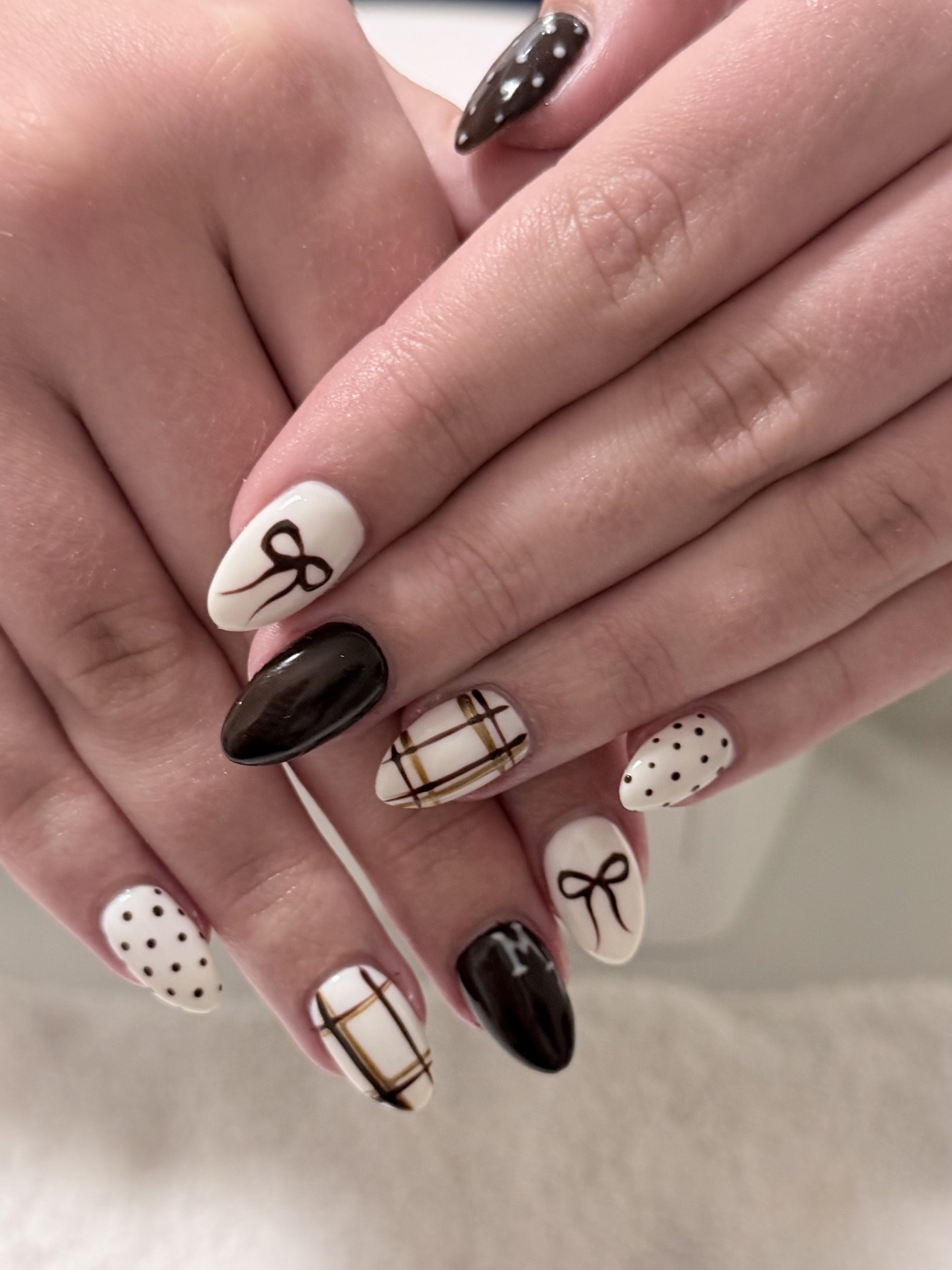 Cream and dark brown nails with hand-painted bows, polka dots and gold plaid